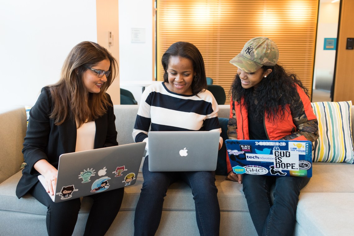 Three women working on laptops, talking to each other (Image: WOCInTechChat, CC-BY)