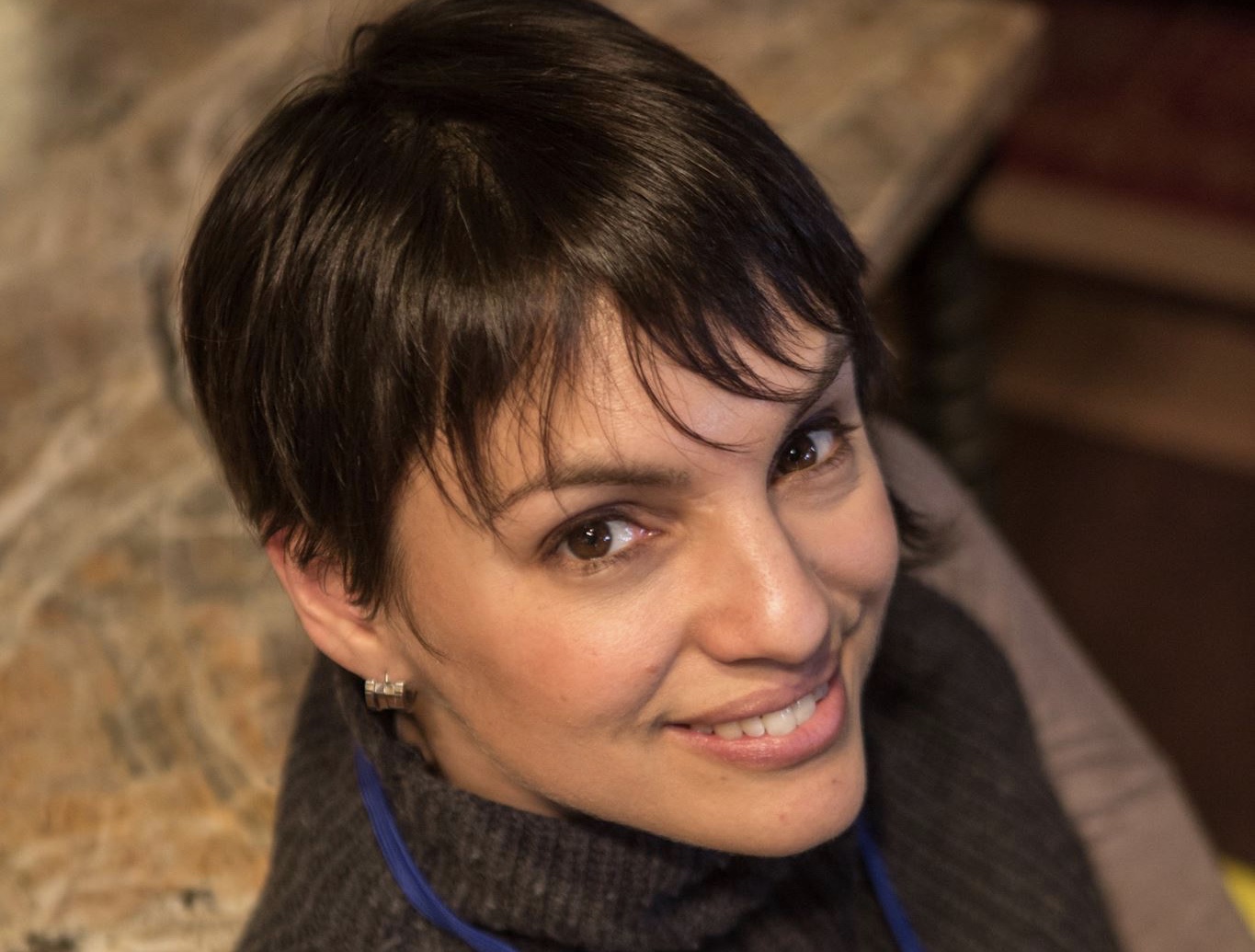 [IMAGE] Picture of interview subject Mónica Guzmán. It is taken from above. She is looking up at the camera and smiling.